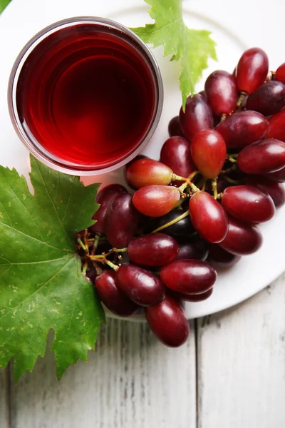 Glass of grape juice on wooden table, closeup — Stock Photo, Image