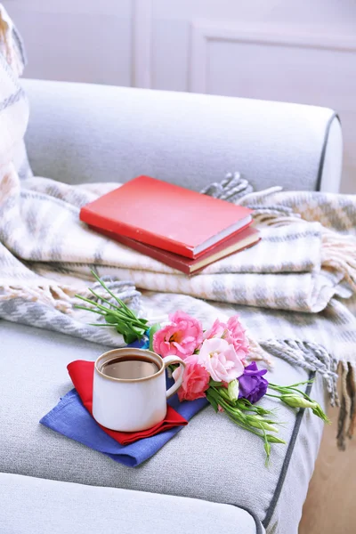 Чашка кофе с цветами возле книг — стоковое фото