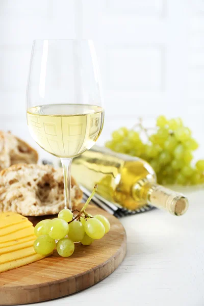 Bodegón de vino, uva, queso y pan sobre fondo claro — Foto de Stock