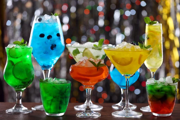 Glasses of cocktails with ice on blurred lights background — Stock Photo, Image