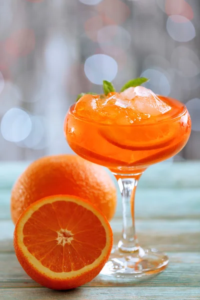 Glass of cocktail with ice on blurred lights background — Stock Photo, Image