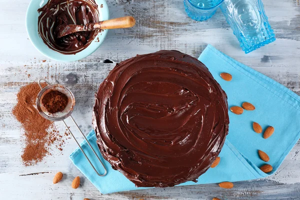 Leckeren Kuchen unter Schokoladenglasur auf hellblauem Hintergrund — Stockfoto