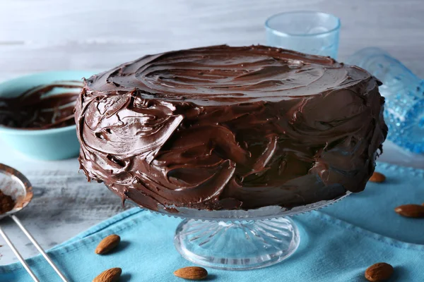 Вкусный торт под шоколадной глазурью на светло-голубом фоне — стоковое фото