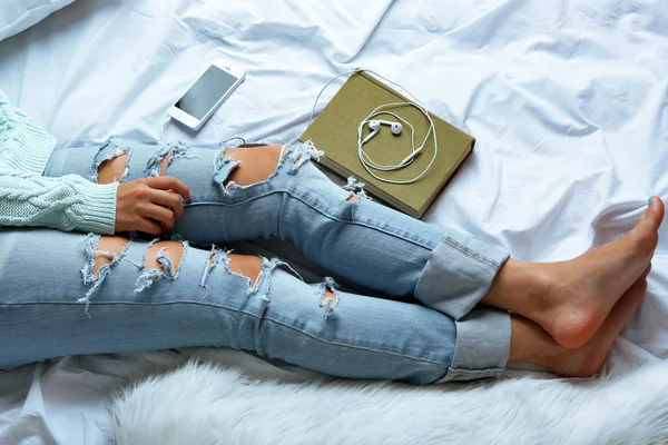 Frau in Jeans auf dem Bett — Stockfoto