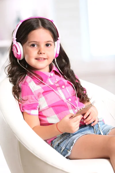 Attractive little girl sitting on chair — Stock Photo, Image