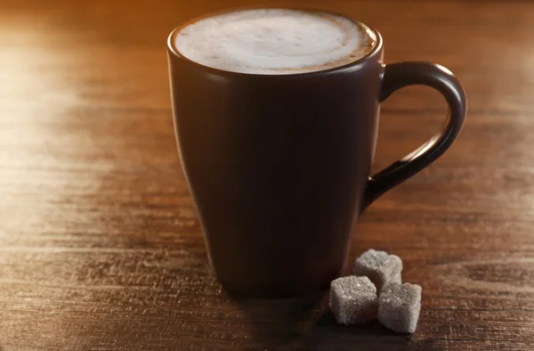 Tasty hot coffee with three pieces of sugar on wooden background — Stok fotoğraf