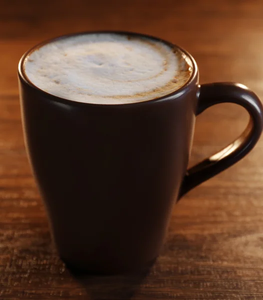 Brown ceramic cup of coffee on wooden table, close up — Stockfoto