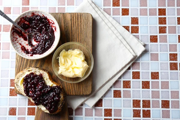 접시, 그릇, 나무 태블릿에 빵과 모자이크 배경에 냅킨에 버터에 맛 있는 잼 — 스톡 사진