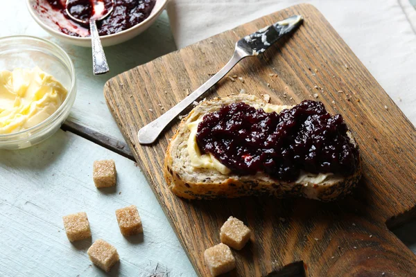 Chutné jam v misce, máslo, čerstvý chléb a sušenky na modrém pozadí dřevěná — Stock fotografie