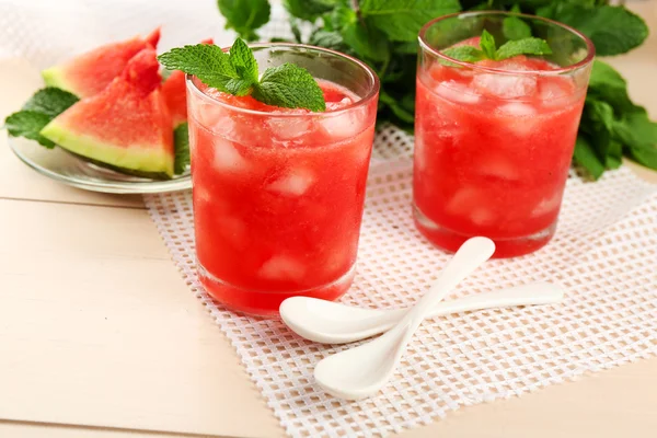Cold watermelon drinks in glasses, on wooden table background — Stock Photo, Image