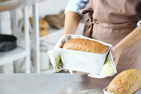 Bäcker überprüft frisch gebackenes Brot in Bäckereiküche — Stockfoto