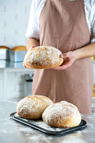 Baker verificando pão recém-assado na cozinha da padaria — Fotografia de Stock