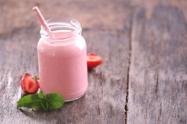 Nane ve ahşap arka plan üzerinde etrafında meyveleri ile sağlıklı çilekli yoğurt