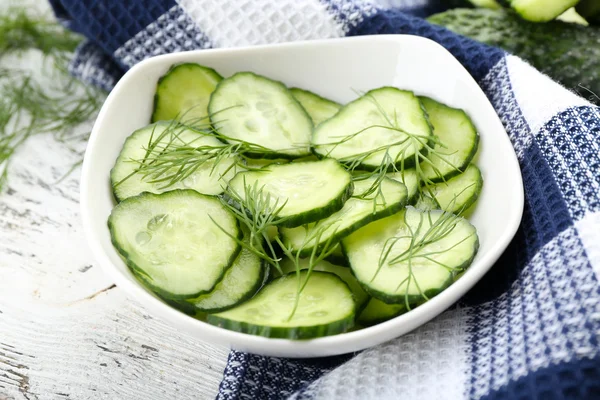 Pepinos en rodajas en plato blanco con servilleta de algodón azul a cuadros — Foto de Stock