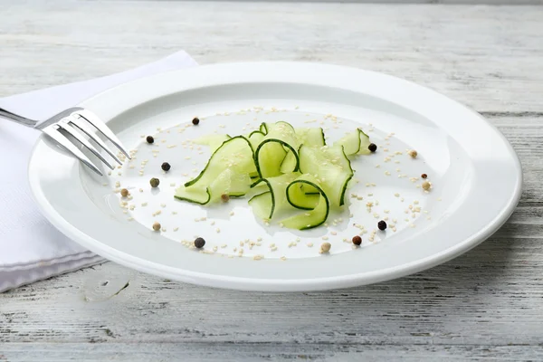 Plátky okurky salátové misky na bílém štítku v restauraci, zblízka — Stock fotografie