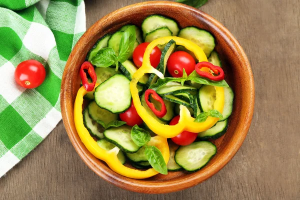 Ensalada de verduras con pepinos sobre fondo de madera decorada con servilleta de algodón verde y pimiento dulce —  Fotos de Stock