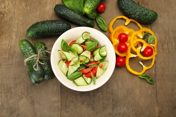 Salatalık ve biber ahşap arka plan üzerinde sebze salatası — Stok fotoğraf