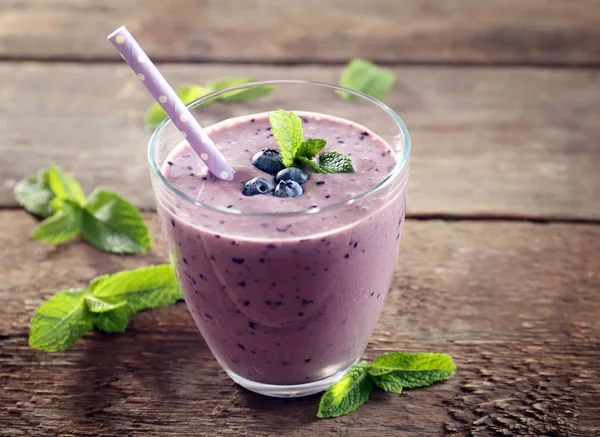 Leckerer Blaubeerjoghurt mit Beeren und Minze auf Holzgrund dekoriert — Stockfoto