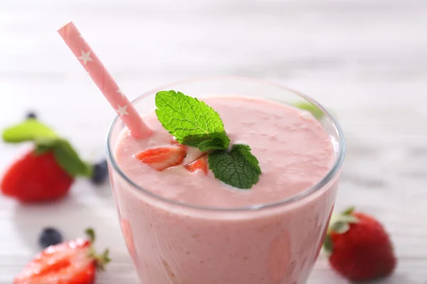 Yogurt de fresa fresca con bayas alrededor sobre fondo de madera clara, de cerca — Foto de Stock