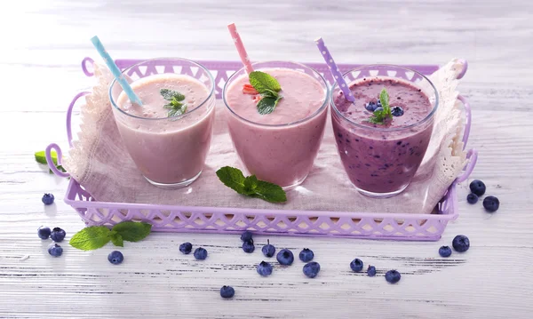 Chutné jahody, borůvky a mléko jogurt na serveru v řadě proti světlé dřevěné pozadí — Stock fotografie