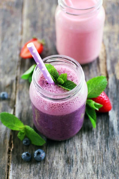 Gesunder Erdbeerjoghurt mit Minze und Beeren auf Holzgrund, Nahaufnahme — Stockfoto