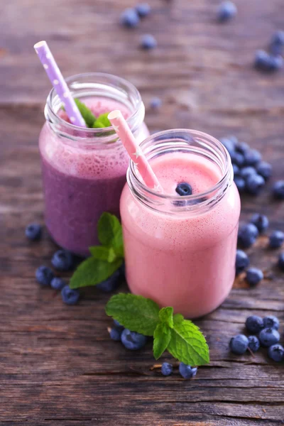 Healthy strawberry yogurt with mint and berries around on wooden background — Stock Photo, Image