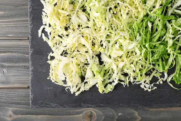 Cut savoy cabbage on wooden background — Stock Photo, Image