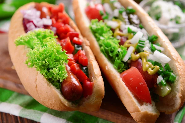 Hot dogot és zöldségek, a fa vágódeszka — Stock Fotó