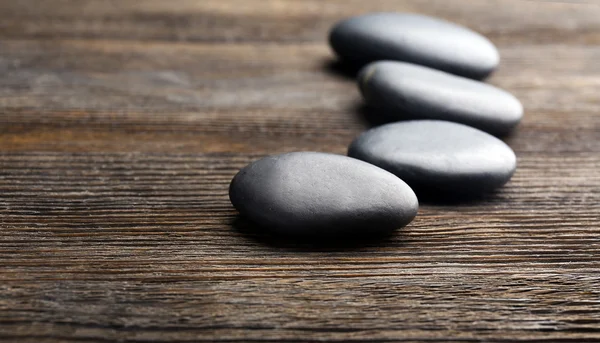 Pebbles in a row on wooden background — Stock Photo, Image