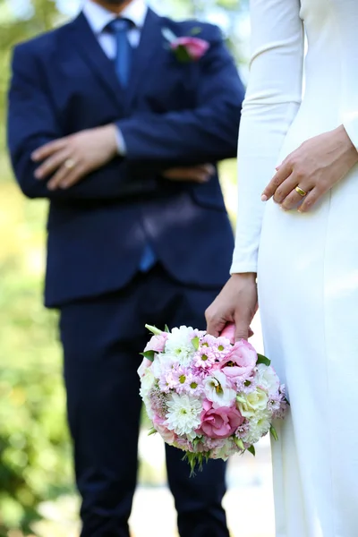 Brud med bröllop bukett och brudgummen på natur bakgrund — Stockfoto