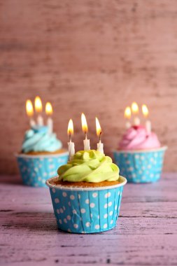 Ahşap arka plan karşı Menekşe masada mumlarla lezzetli kek