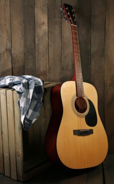 Ahşap duvar arka plan üzerinde sandık gitar ve gömlek yaptı