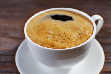 Tahta arka planda bir fincan kahve.