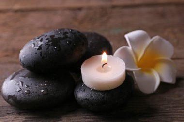 Rahatlatıcı kavramı - fragipani çiçek, taş ve ahşap zemin üzerine mumlar