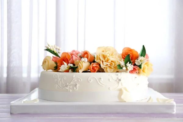 Elegante pastel de boda decorado con flores en la mesa en la habitación — Foto de Stock