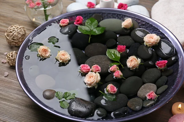 Spa samenstelling van kaarsen, bloemen en stenen in water, op houten achtergrond — Stockfoto