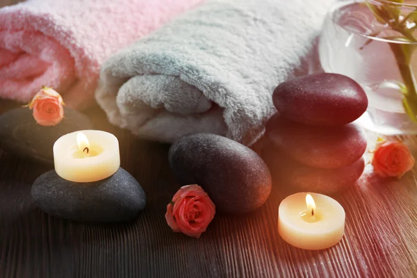 Spa composizione di candele, fiori e pietre su sfondo di legno marrone — Foto Stock