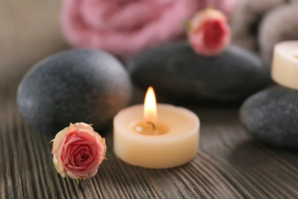 Composición spa de velas, flores y piedras sobre fondo de madera marrón — Foto de Stock