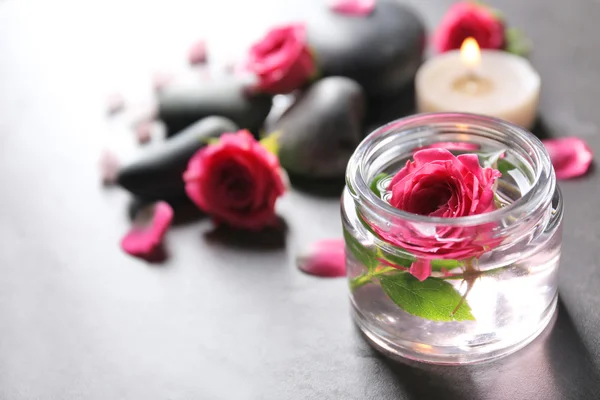 Spa-skład świece, kamienie i kwiaty, na szarym tle — Zdjęcie stockowe