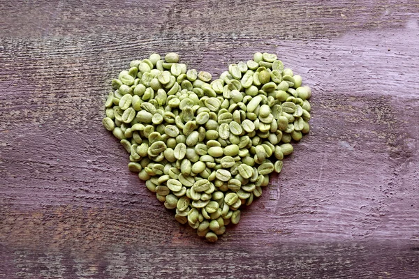 Cacahuetes en forma de corazón sobre fondo de madera —  Fotos de Stock