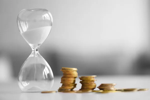 Antique Hourglass with coins — Stock Photo, Image