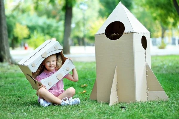 Fată în casca de carton lângă racheta din cutie — Fotografie, imagine de stoc