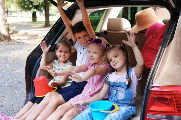 Kinderen zitten op de auto kofferbak — Stockfoto