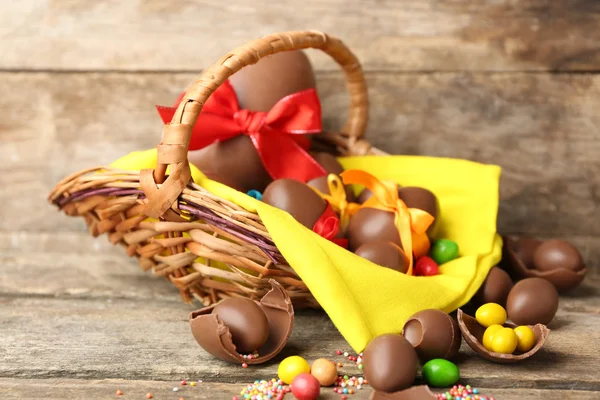Čokoládová velikonoční vejce v košíku na dřevěné pozadí — Stock fotografie