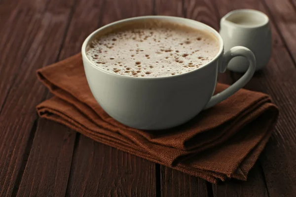 Чашка кофе на коричневой салфетке крупным планом — стоковое фото