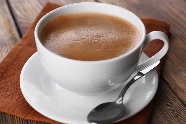 Secangkir kopi pada tutup serbet coklat — Stok Foto