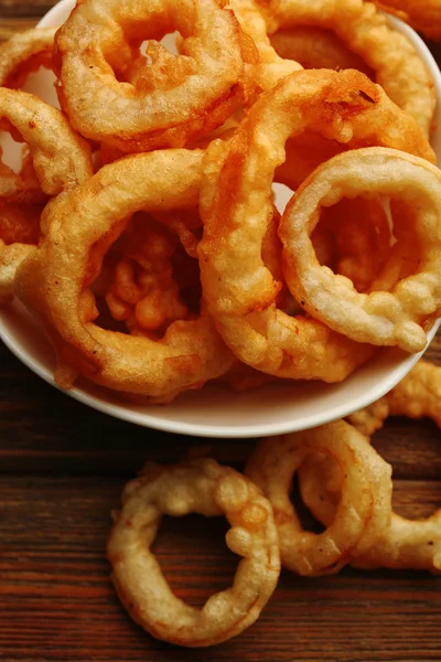 Chips anéis em tigela no fundo de madeira — Fotografia de Stock