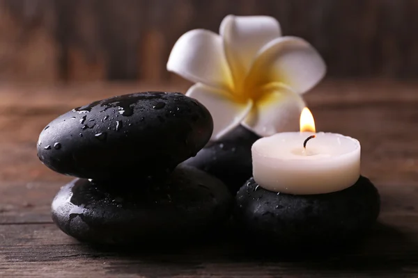 Relaxing concept - fragipani flower, pebbles and candles on wooden background — Stock Photo, Image