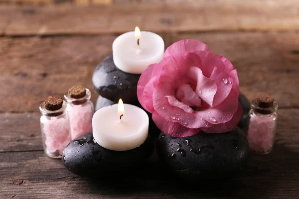 Luz velas, seixos e composição de flores de aroma fresco no fundo de madeira — Fotografia de Stock