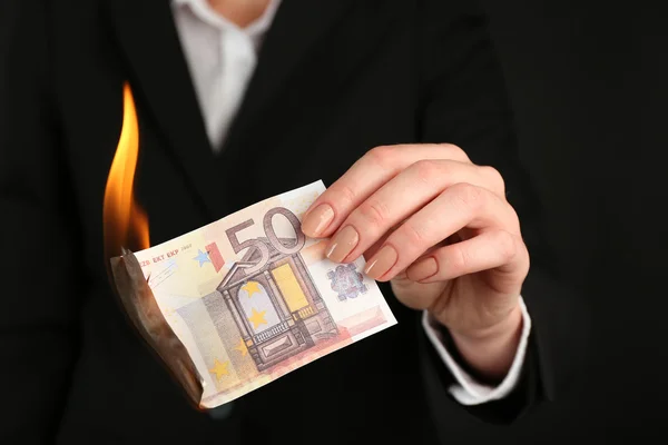 Woman burning Euro banknotes closeup Stock Picture